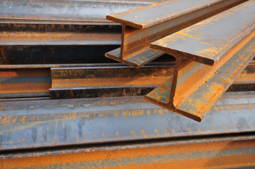 Rusting steel beams showing significant corrosion in an outdoor construction setting, highlighting the need for effective rust removal techniques and preventative maintenance as detailed in the article.